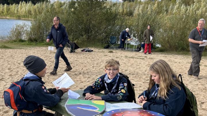 Tre spejdere sidder ved et bord til Sct. Georgsgildeløbet